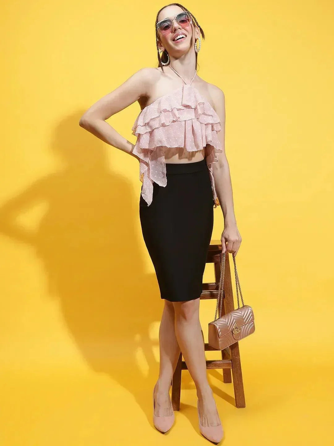 Oxolloxo pink halter neck crop top with ruffle detailing worn with black skirt and sunglasses